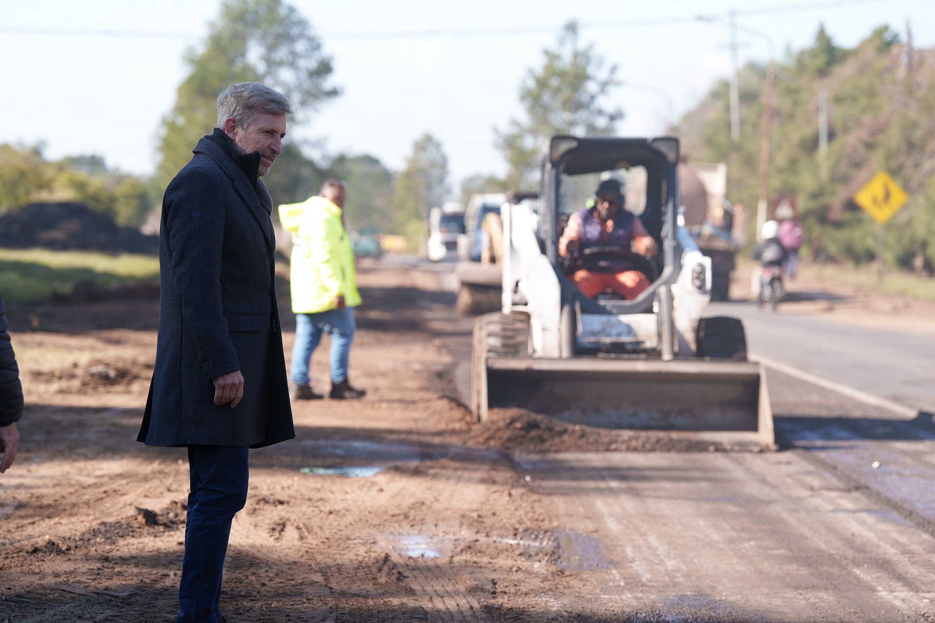 alt="El gobernador entrerriano observa maquinaria pesada trabajando en el asfalto durante las obras en rutas 4 y 22"