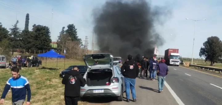 alt="Manifestantes congregados al costado de la ruta con quema de neumáticos y humo denso en el marco de la protesta en la Autovía 14"