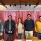 alt="Cinco profesionales de Codesal y el Colegio de Arquitectos de pie frente a banners institucionales rojos, tras acordar la planificación de proyectos para el lago Salto Grande"