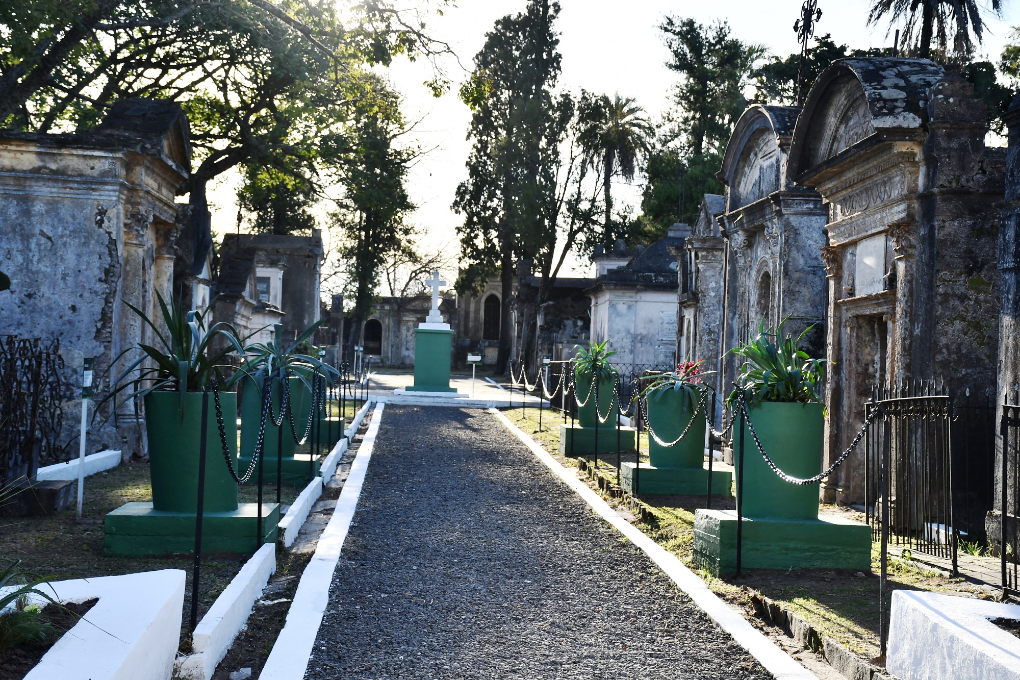 alt="Vista del sendero y mausoleos del Cementerio de los Fundadores al atardecer, listos para el evento nocturno"