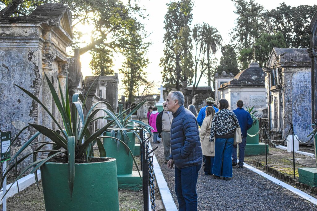 alt="Grupo de asistentes observando una representación en el Cementerio de los Fundadores, como parte del ciclo de Noches en el Cementerio"