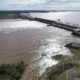 alt="Vista aérea del complejo de Salto Grande con alta turbulencia en vertederos, alertando sobre la crecida del Río Uruguay por El Niño"