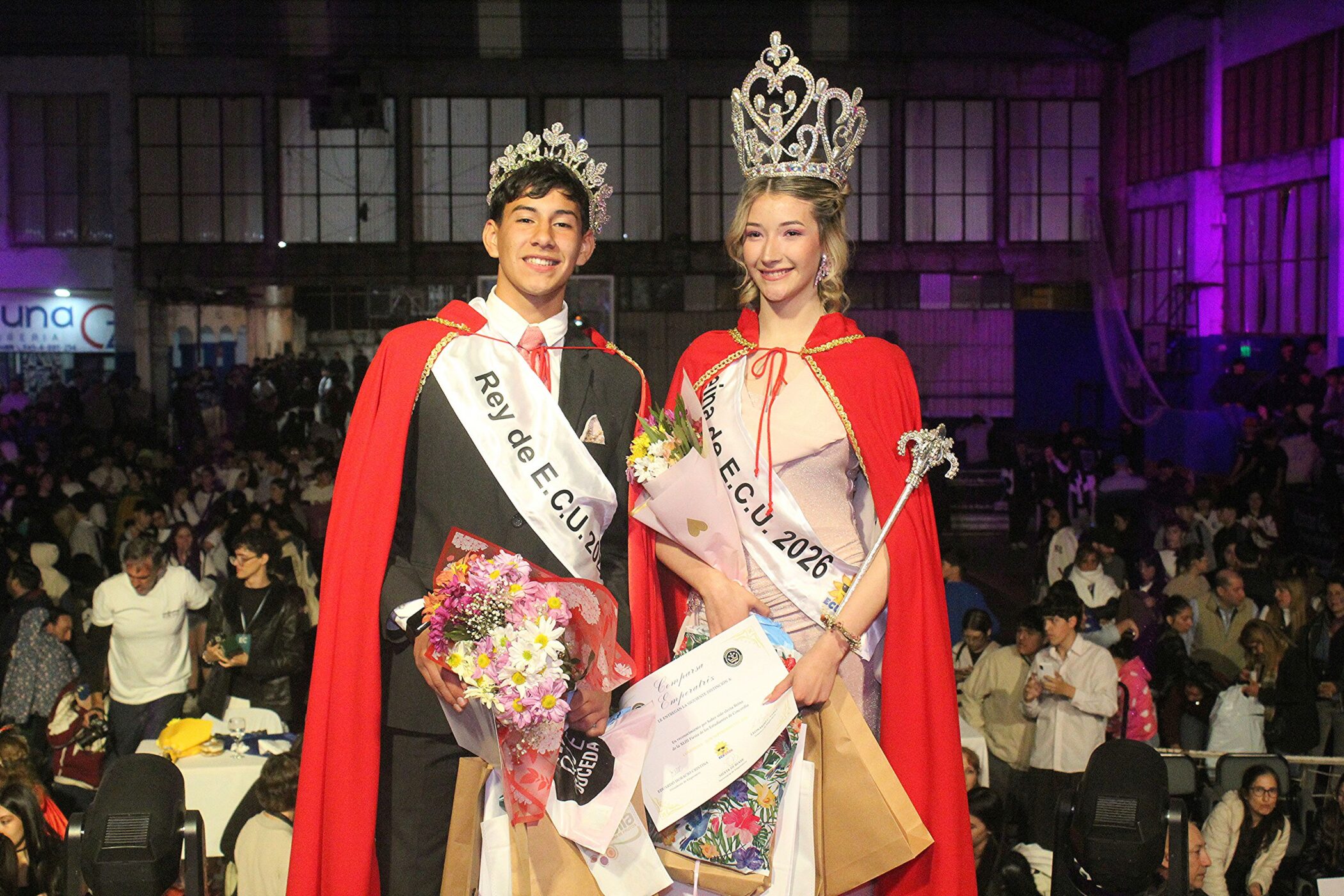 alt="Reina y Rey de la Fiesta de los Estudiantes de Concordia 2026, Leila Rebot y Jeremías Miño, con corona y capa roja"