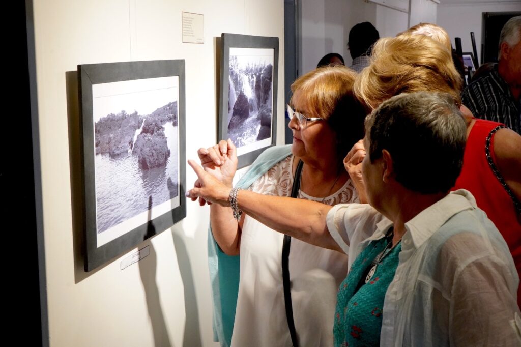 alt="Personas observando fotos antiguas en el aniversario del Museo de Salto Grande"