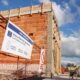 alt="Cartel de la obra de agua potable de Concordia frente al edificio de la nueva planta potabilizadora en construcción"