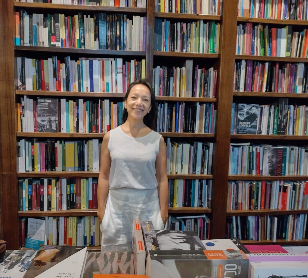 alt="Alejandra Kamiya, autora invitada a la Feria Provincial del Libro Concordia 2026, frente a una biblioteca"