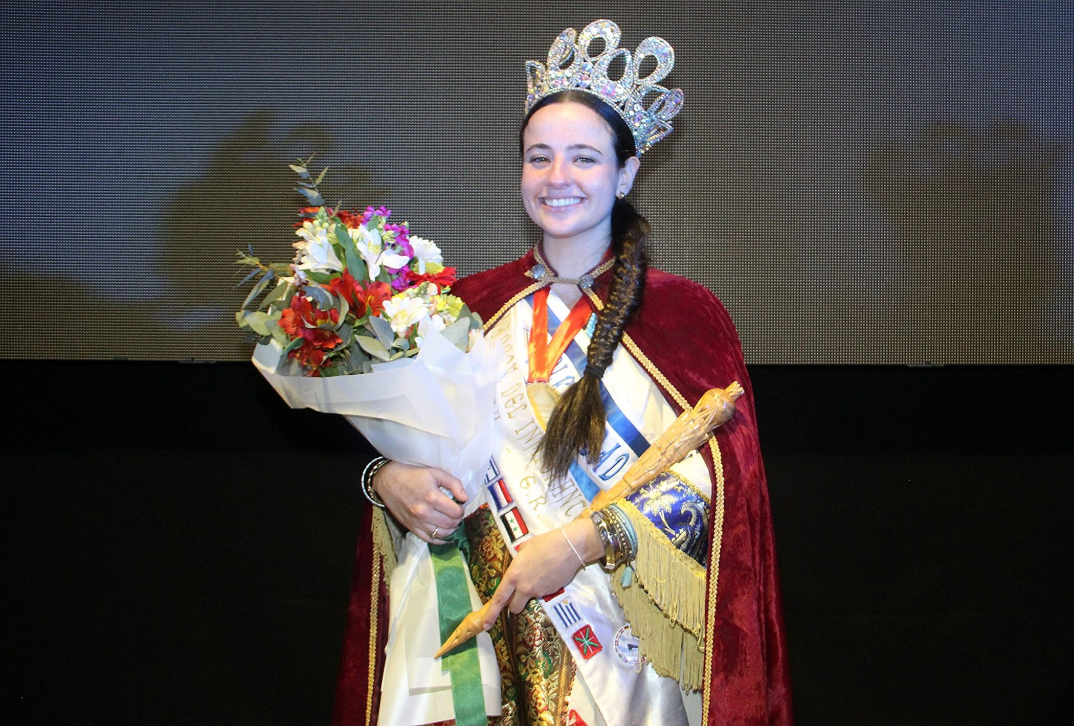 alt="Amiela Mendelovich Visnevetzky, Reina Provincial del Inmigrante 2026, posa con corona, cetro y banda en el Centro de Convenciones de Concordia"