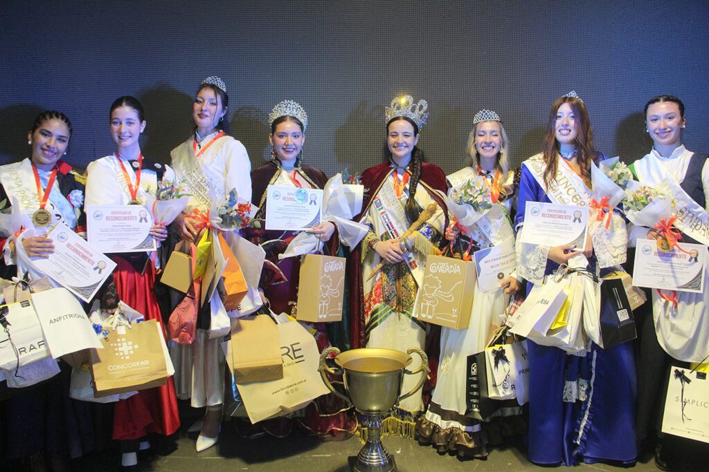 alt="La Reina Provincial del Inmigrante 2026 y su corte de princesas, misses y anfitriona posan en el escenario del Centro de Convenciones de Concordia"