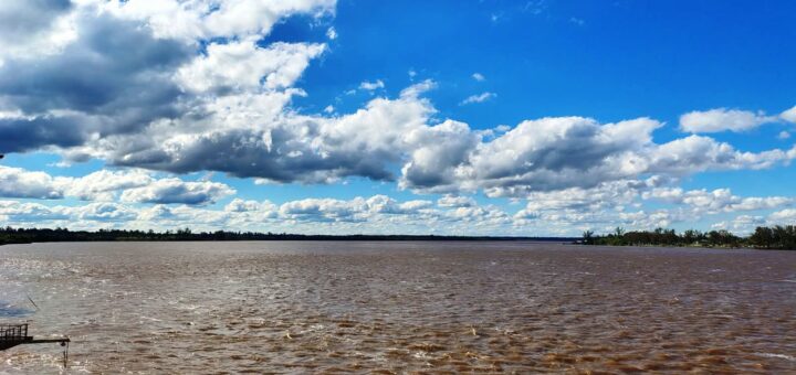 Río Uruguay de aguas marrones bajo un cielo con nubes frente a Concordia durante la crecida del río Uruguay.