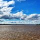 Río Uruguay de aguas marrones bajo un cielo con nubes frente a Concordia durante la crecida del río Uruguay.