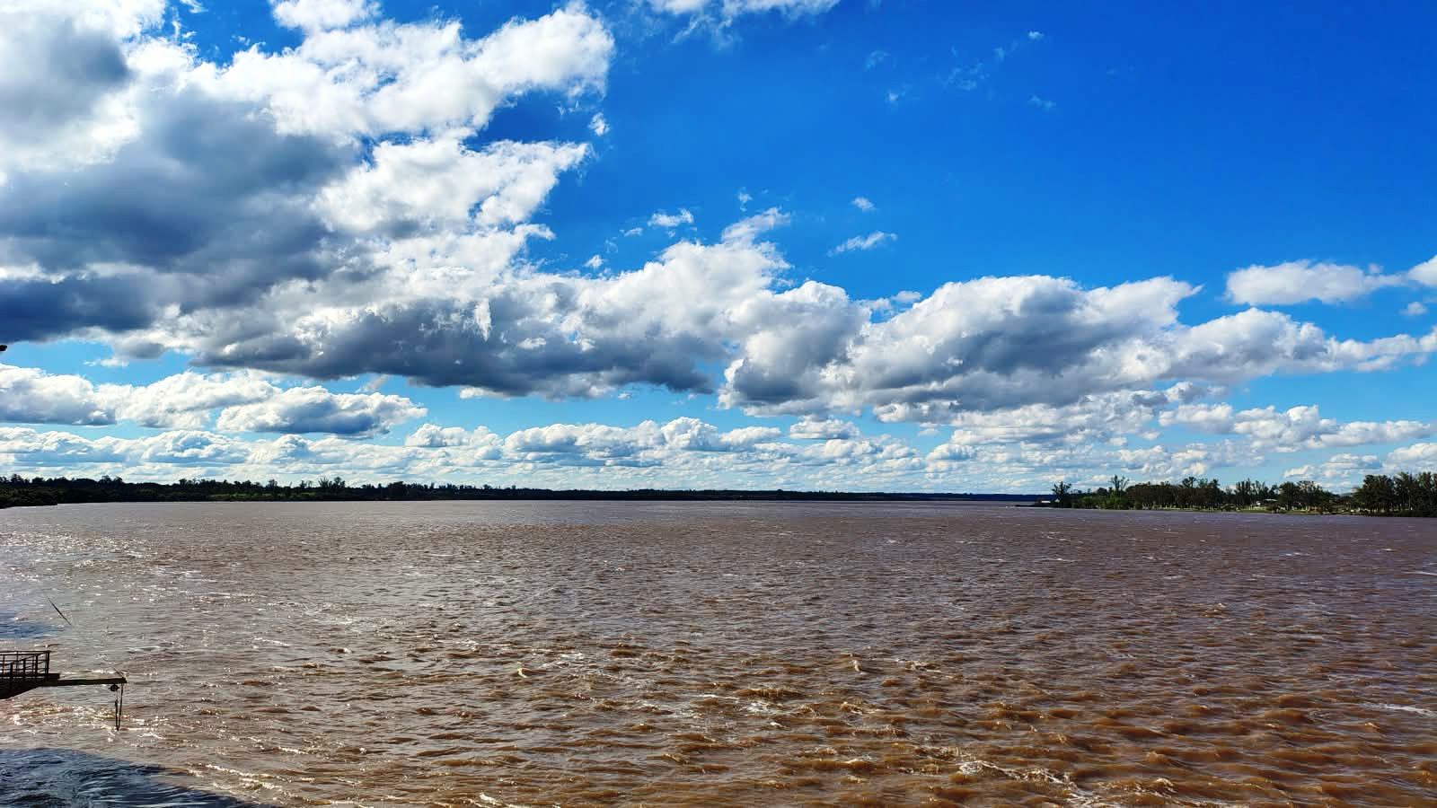 Río Uruguay de aguas marrones bajo un cielo con nubes frente a Concordia durante la crecida del río Uruguay.