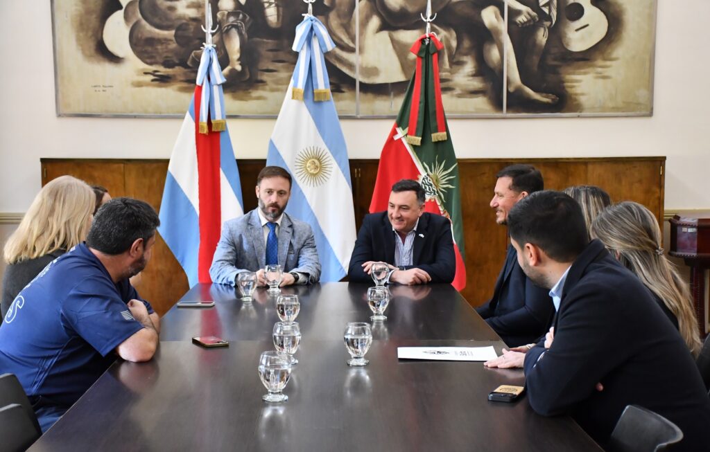 alt="Autoridades de Concordia y Salto sentadas a una mesa con banderas, en una reunión por la crecida del río Uruguay en Concordia"