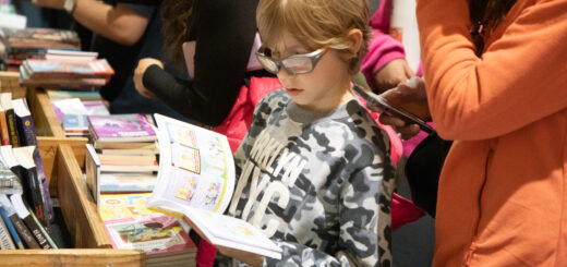 alt="Niño leyendo una historieta en un stand de la Feria Provincial del Libro en Concordia"