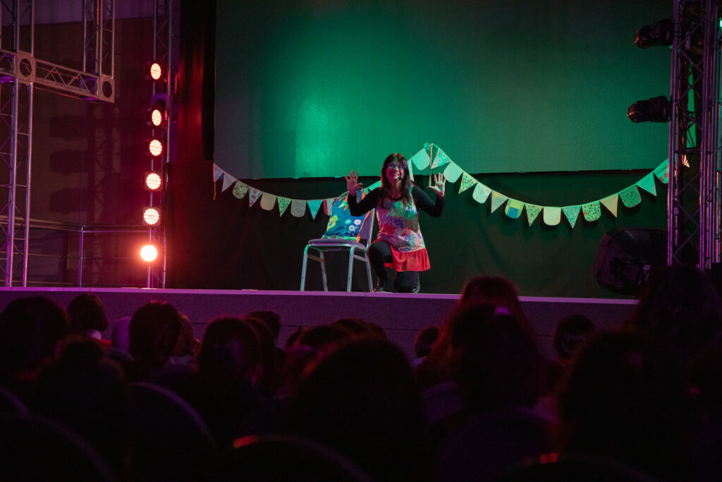 alt="Artista presentando un espectáculo ante el público en la Feria Provincial del Libro en Concordia"