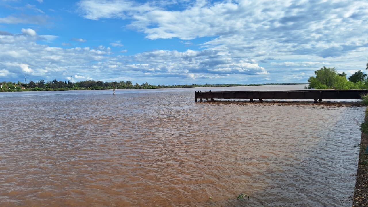 alt="Aguas marrones del río Uruguay crecido frente a Concordia, con una estructura metálica sobre el agua, en el marco de la prevención ante El Niño en Entre Ríos"