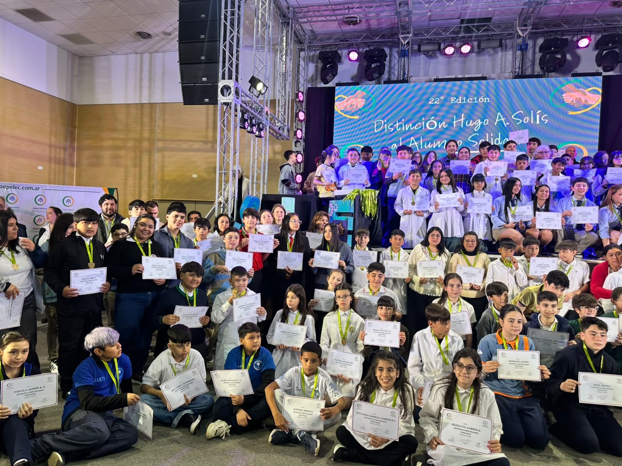 alt="Estudiantes distinguidos con la distinción Hugo Solís al alumno solidario en Concordia posan con sus certificados en el Centro de Convenciones de Concordia"