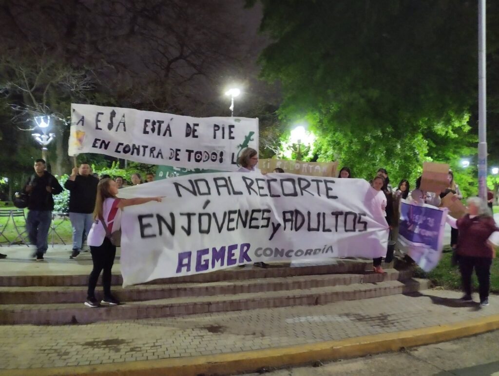 alt="Carteles de la ESA y de AGMER Concordia en la movilización nocturna por la reforma curricular de Jóvenes y Adultos"