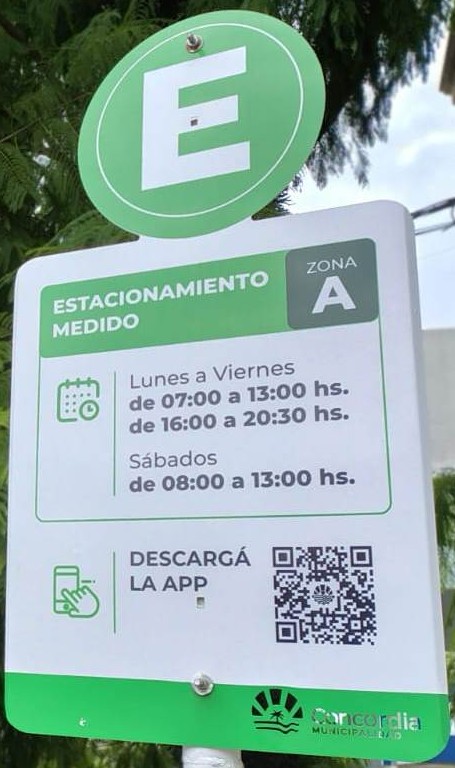 alt="Detalle del cartel con horarios y código QR en una calle donde rige el estacionamiento medido liberado en Concordia"