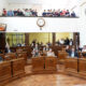 alt="Concejales de Concordia con la mano en alto durante la votación de la Ley de Grandes Superficies en Concordia, con público en la galería del recinto"
