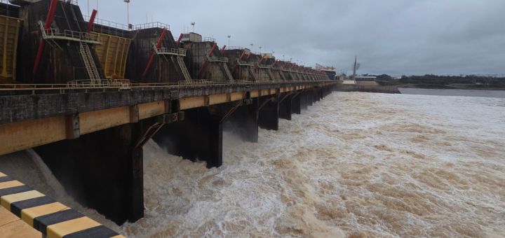 alt="Vertedero de la represa de Salto Grande abierto durante la crecida del río Uruguay en Concordia y Salto el 26 de octubre de 2026, con gran caudal de agua marrón"